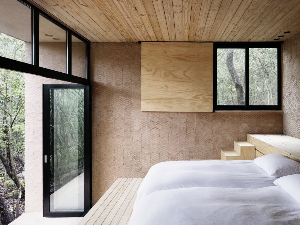 rammed-earth-brick-and-wood-give-the-bedroom-a-warm-rustic-atmosphere